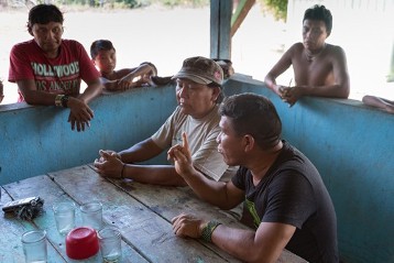 Armindo Goes Melo  (rechts) und Davi Kopenwa Yanomami (Mitte), (Chefs der Yanomami-Organisation „Hutukara“ )-hier im Gespräch mit Yanomami im Stützpunkt Dimini kurz nach ihrer Landung.