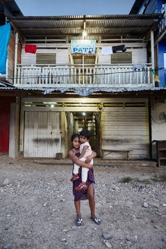 Bewohnerin in Delta 1 mit Kind auf dem Arm bei anbrechender Nacht