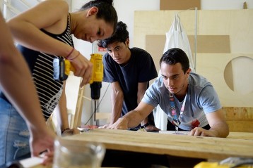 Jugendliche bauen eine "Seifenkiste", betreut von Vinicius Santos (21 Jahre, graues T-Shirt), Projektarbeit im Ausbildungszentrum "Fab Lap", Favela Heliopolis. „Fab Lab“ steht für die Mischung aus Fabrik und Laboratorium