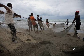 Fischer am Strand von Torbeck ziehen gemeinsam ein Schleppnetz aus dem Wasser