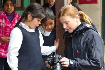 In der Schule in Dewepille werden Mapuche-Kinder in ihren Stammessprachen unterrichtet und bekommen ihre Kultur vermittelt. Schülerinnen mit Adveniat-Pressesprecherin Carolin Kronenburg auf dem Außengelände der Schule.