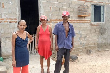 Landarbeiterin Maria Magnólia da Silva mit Sohn und Schwiegertochter vor ihrem Haus