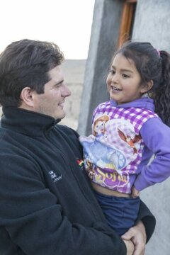 Padre Lucas mit einem Kind Im Bergdorf La Hoyada.