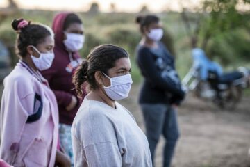 Schwester Neusa do Nascimento und Schwester Leticia versammeln sich mit Dorfbewohnern - alle mit Schutzmaske und Sicherheitsabstand.