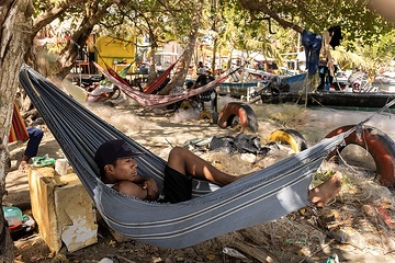 Migranten ruhen sich am Strand von Necoclí aus. Necoclí ist ein Touristendorf in Kolumbien, der nicht in der Lage ist, die Hunderten von Migranten unterzubringen, die jede Woche ankommen.