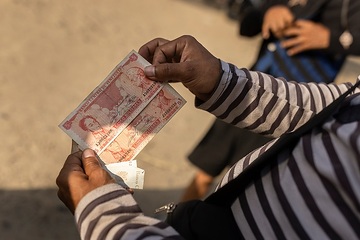 Migranten zeigen venezolanische Banknoten (Bolivar). Die Abwertung war so groß, dass ihr Geld nichts mehr wert ist.