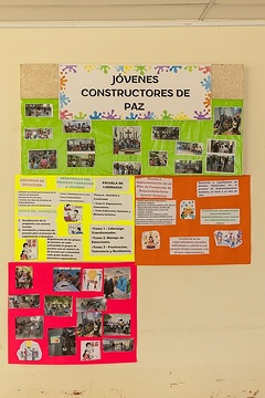 Fotos und Hausplakate über das Projekt "Junge Friedenmacher" (Jóvenes constructores de paz) bei der Caritas Hauptstelle in San Bartolo, Chalatenango.